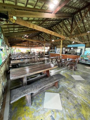 un restaurante con bancos de madera en el medio de una habitación en Pousada Recanto dos Cisnes, en Betim