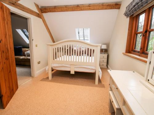 a baby room with a crib and a window at Pultheley Cottage in Montgomery