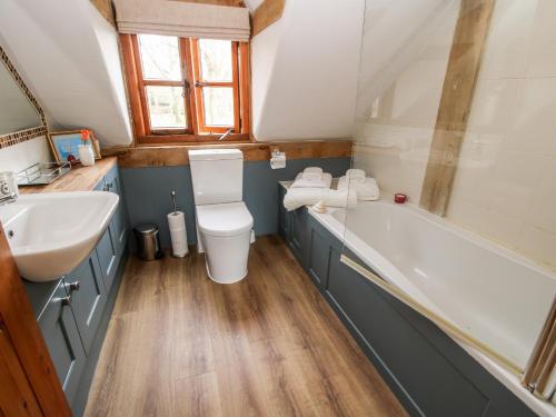 a bathroom with a sink and a toilet and a tub at Pultheley Cottage in Montgomery