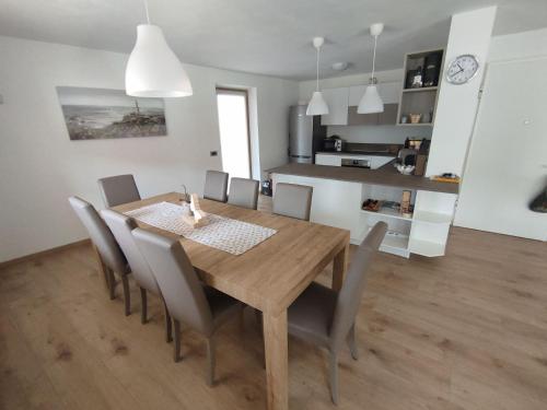 a kitchen and dining room with a wooden table and chairs at Nuovo Appartamento con Giardino in Folgaria