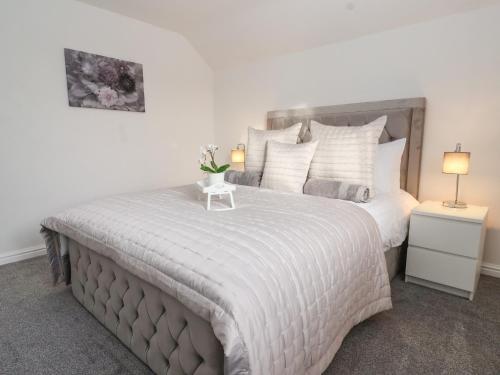 a bedroom with a large bed and two lamps at The Coastal Hideaway in Hornsea