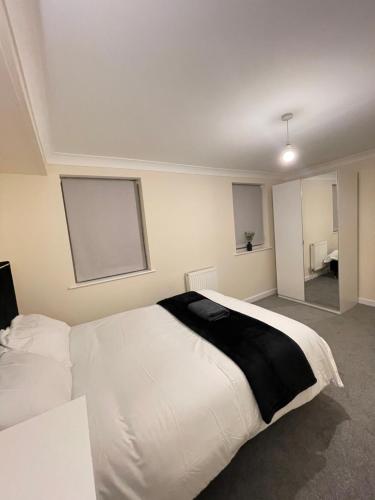 um quarto com uma cama branca e um cobertor preto em Relaxing double rooms in a beautiful house em Ipswich