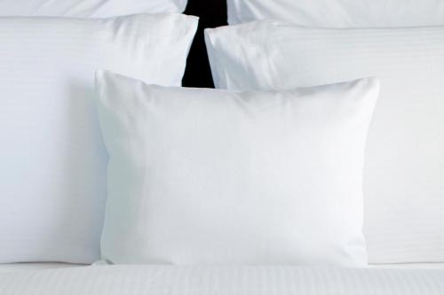 a group of white pillows on a bed at InterContinental Santiago by IHG in Santiago