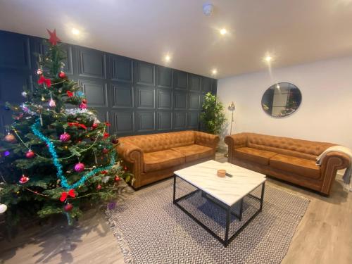 17A Stella house nr Bath في رادستوك: غرفة معيشة مع شجرة عيد الميلاد وأريكة
