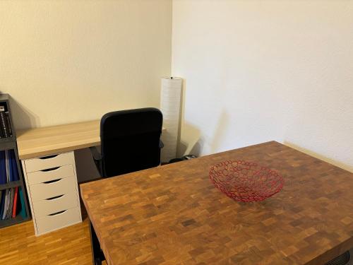 an office with a wooden table and a black chair at MG APPARTEMENT CHAMPEL in Geneva