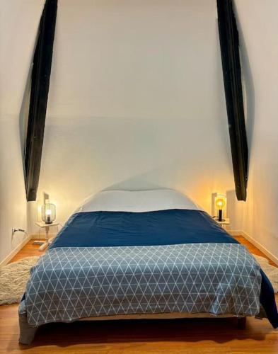 sypialnia z łóżkiem w pokoju z 2 lampami w obiekcie Ancienne Chapelle du Château 