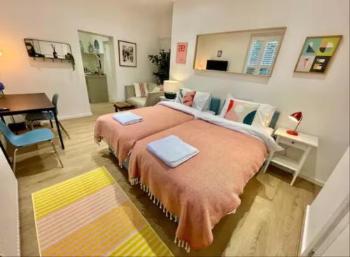 um quarto com uma cama grande com duas toalhas em Orange Rentals-Cosy Annexe, Alfresco charm em Liverpool