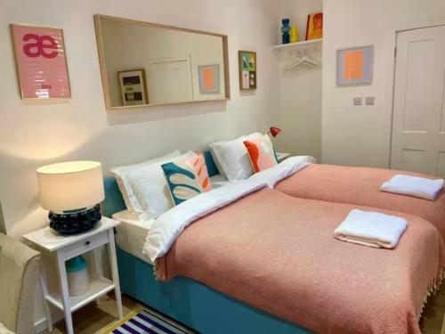 a bedroom with two beds and a mirror at Orange Rentals-Cosy Annexe, Alfresco charm in Liverpool