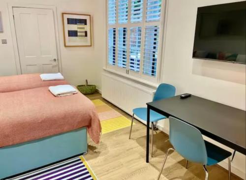 a room with a bed and a table and chairs at Orange Rentals-Cosy Annexe, Alfresco charm in Liverpool