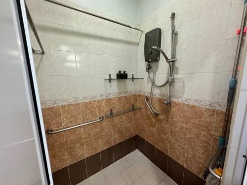 a shower in a bathroom with a tiled floor at Cozy House 37 @ Alma BM in Bukit Mertajam