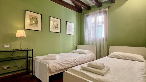 Habitación verde con 2 camas y ventana en Residence Flowery en Venecia