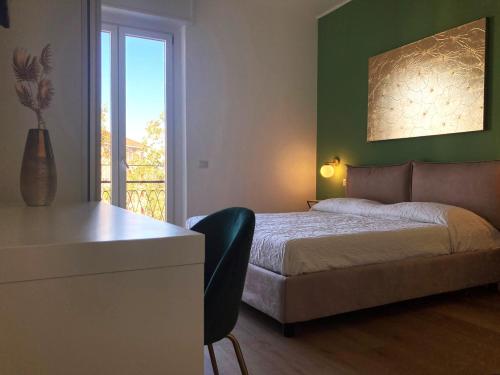 a bedroom with a bed and a desk and a window at Elegante e spazioso appartamento in Milan