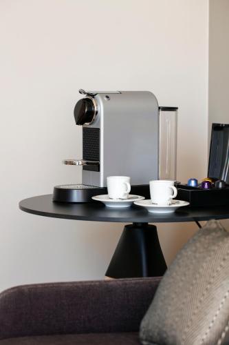 a table with two cups and a coffee machine at Hilton Garden Inn Bordeaux Centre in Bordeaux