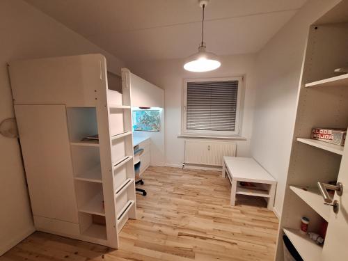a room with a white book shelf and a desk at Apartment Hundige in Greve