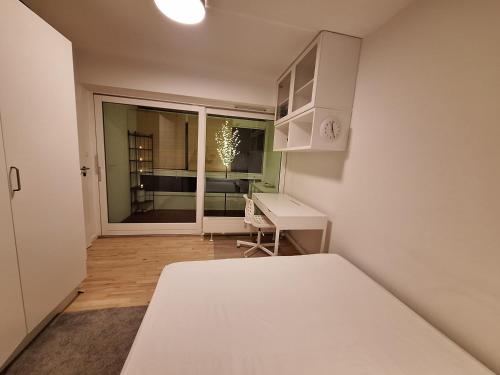 a bedroom with a bed and a desk and a window at Apartment Hundige in Greve