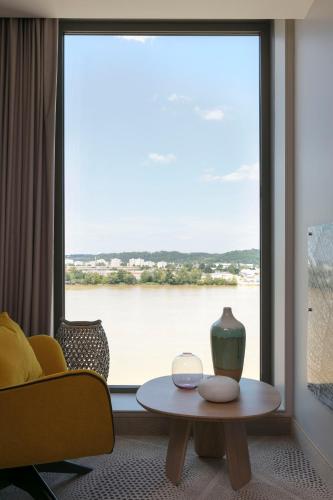 a living room with a view of a large window at Hilton Garden Inn Bordeaux Centre in Bordeaux