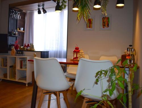 une salle à manger avec une table et deux chaises blanches dans l'établissement Mila Apartment, à Skopje
