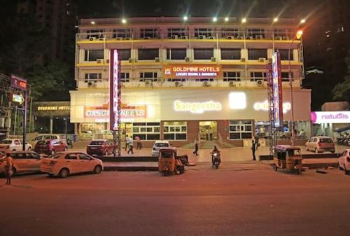 a building with cars parked in front of it at night at GOLDMINE HOTELS in Chennai