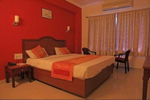 a bedroom with a bed and a table and a window at GOLDMINE HOTELS in Chennai