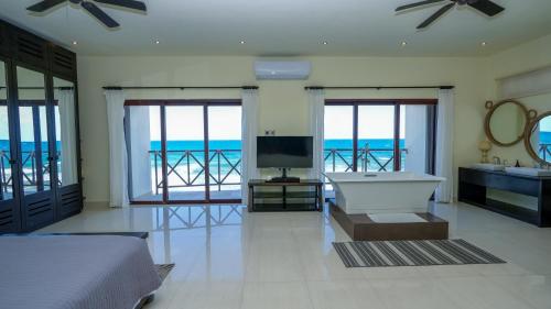 a bedroom with a bed and a tub and a television at Casa Javi- Ocean Front located Mid Isla Mujeres in Isla Mujeres