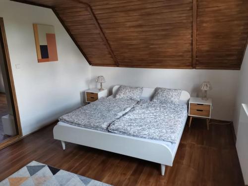 a bedroom with a bed and a wooden ceiling at Cozy cottage Geltschberg Nr. 1 in Liběšice