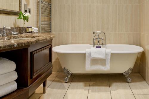 a bathroom with a bath tub and a sink at Lough Erne Resort in Enniskillen