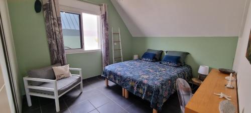 1 dormitorio con 1 cama, 1 silla y 1 ventana en Appartement Corail, situé à 2 min du lagon, en Saint-Leu