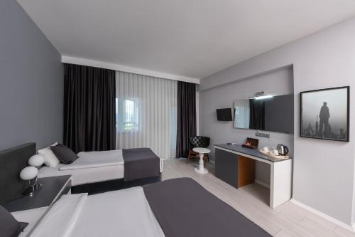 a hotel room with a bed and a television at Expo Park Hotel in Antalya