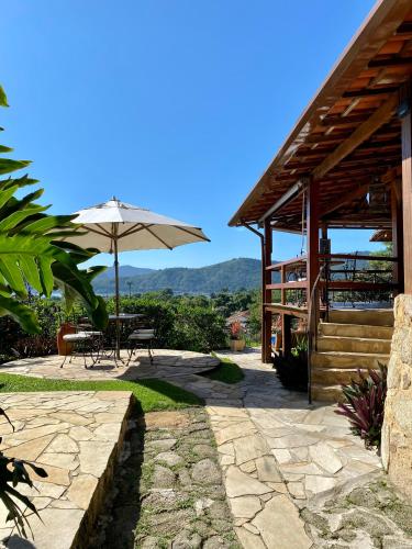 a patio with a table and an umbrella at Pousada Morro do Forte in Paraty
