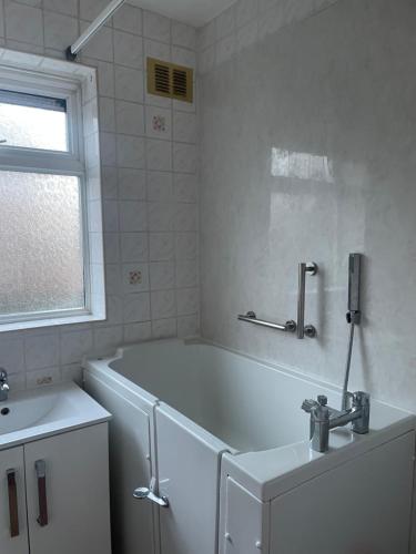 een witte badkamer met een bad en een wastafel bij Spacious 2 Bedroom Apartment in Zone 2 LONDON in Londen