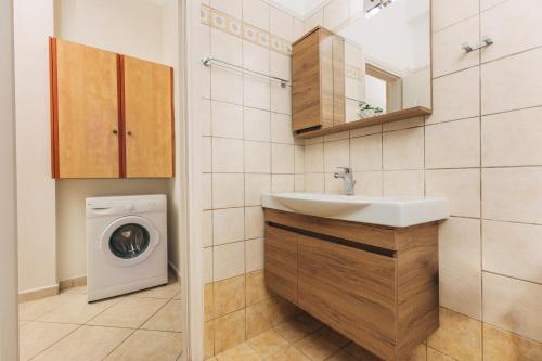 ein Badezimmer mit einer Waschmaschine und einem Waschbecken in der Unterkunft Sami's Apartment in Ambelókipoi