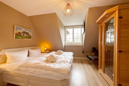 a bedroom with a white bed in a room at Ameland Reethus in Wenningstedt in Wenningstedt