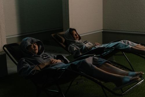 two children sitting in chairs in a room at ヴィランス淡路島 in Sumoto