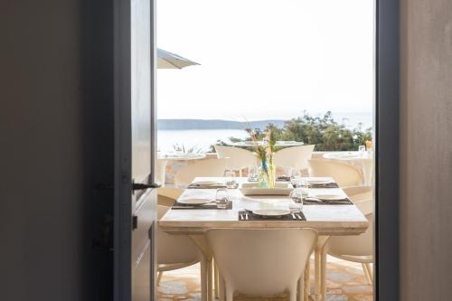 - une table avec des chaises et une table avec vue sur l'océan dans l'établissement Calme Boutique Hotel - Adults Only, à Drios