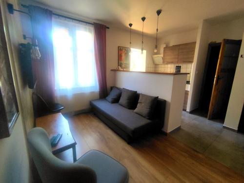 a living room with a couch and a kitchen at Apartament Trawertynowy Chrobrego 15 Sopot in Sopot