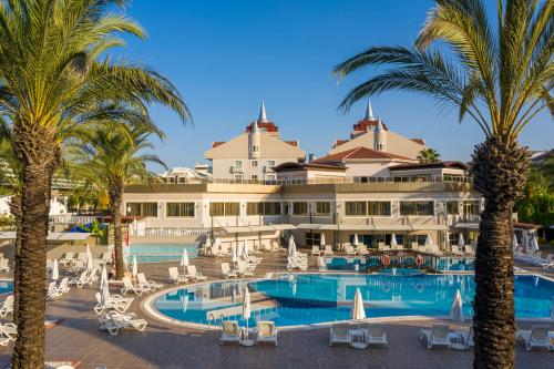 un grande hotel con palme e una piscina di Aydinbey Famous Resort - Ultra All Inclusive a Belek