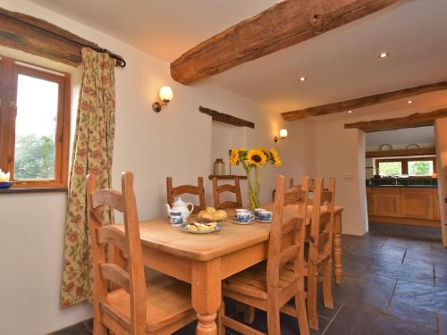 een keuken en eetkamer met een houten tafel en stoelen bij 3 Bed in Winkleigh 1450B in Iddesleigh