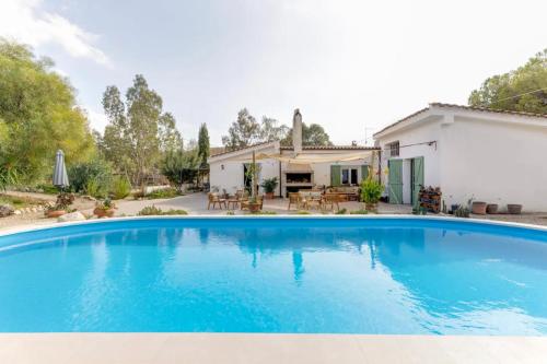 a large blue swimming pool in front of a house at Domu Prexada B&B in Maracalagonis
