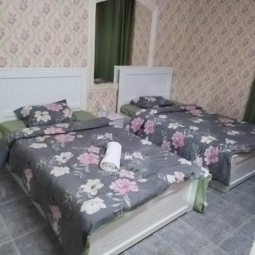 1 dormitorio con 2 camas con flores en العين الهيلي مصباح ب 6, en Al Ain