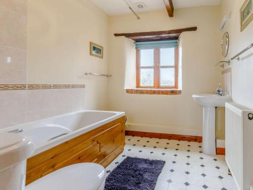 y baño con bañera, lavabo y aseo. en 1 Bed in Holsworthy GBLUE, en Sutcombe