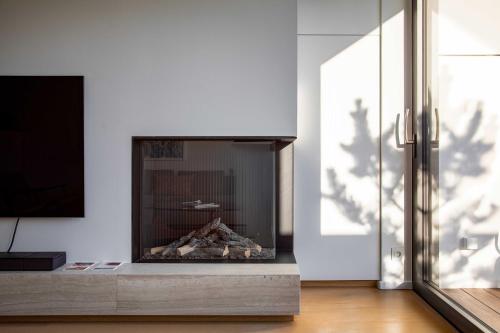 a fireplace in a living room with a white wall at Stunning duplex - 3 bedroom - 2 sunny terrasses in Knokke-Heist