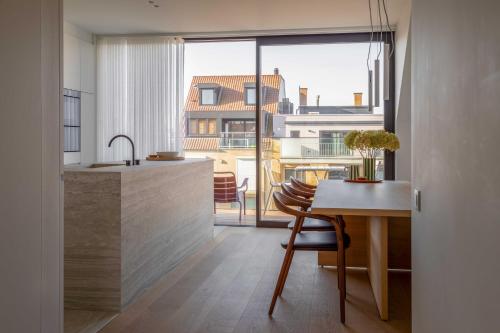 a kitchen with a table and a large window at Stunning duplex - 3 bedroom - 2 sunny terrasses in Knokke-Heist