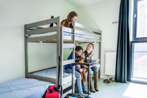 a group of people sitting on a bunk bed at De Ploate Hostel in Ostend