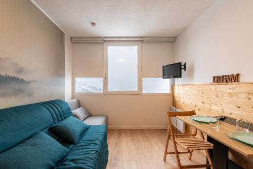 un salon avec un canapé bleu et une table dans l'établissement Bliss - Studio au pied des pistes, à Villarembert