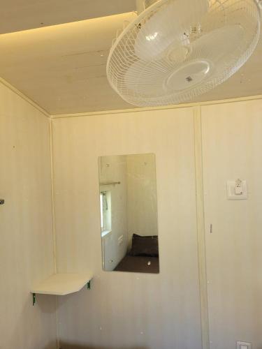 a bathroom with a mirror and a ceiling fan at Farmers Son CampingGround in Sakleshpur