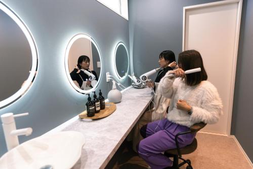 a woman getting her hair cut in a bathroom at ヴィランス淡路島 in Sumoto