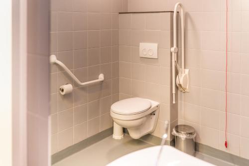 La petite salle de bains est pourvue de toilettes et d'un lavabo. dans l'établissement De Ploate Hostel, à Ostende