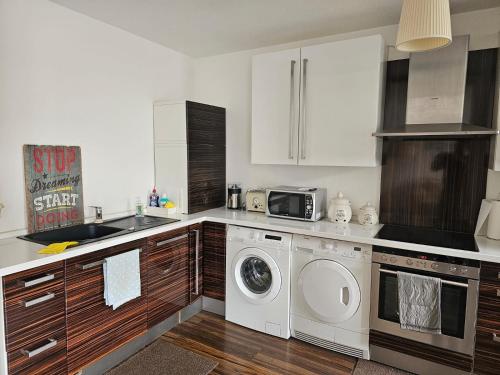 a kitchen with a washing machine and a microwave at Übernachten Sie im wunderschönen Weiden in Cologne