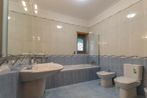 a bathroom with a sink and a toilet and a bath tub at The Ocean View Villa in Viana do Castelo