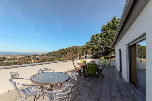 a balcony with tables and chairs and a view at The Ocean View Villa in Viana do Castelo